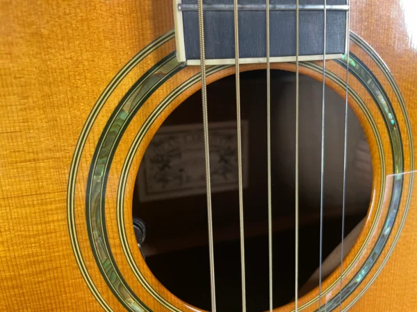 Stunning Made in Canada Jumbo acoustic. 1995. Solid cedar top with ornate koa back and sides. Very nice rosette and beautiful inlays on the fingerboard, and check out that headstock! Large, rich and loud tone with Fishman electronics. Some light general wear throughout as pictured, but nothing significant. Playing great with a fresh setup. Includes original hardshell case.