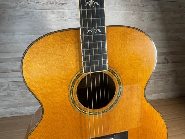 Stunning Made in Canada Jumbo acoustic. 1995. Solid cedar top with ornate koa back and sides. Very nice rosette and beautiful inlays on the fingerboard, and check out that headstock! Large, rich and loud tone with Fishman electronics. Some light general wear throughout as pictured, but nothing significant. Playing great with a fresh setup. Includes original hardshell case.