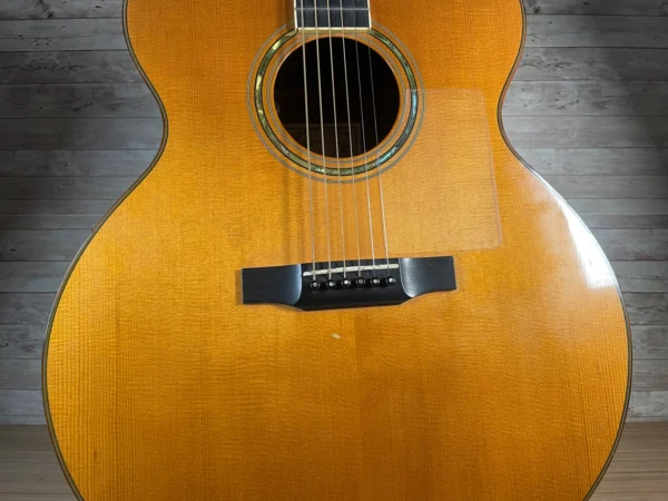 Stunning Made in Canada Jumbo acoustic. 1995. Solid cedar top with ornate koa back and sides. Very nice rosette and beautiful inlays on the fingerboard, and check out that headstock! Large, rich and loud tone with Fishman electronics. Some light general wear throughout as pictured, but nothing significant. Playing great with a fresh setup. Includes original hardshell case.